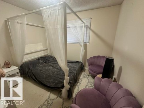 Room featuring neutral-toned walls, carpeting with a geometric pattern, and a window with blinds - 18020 96 Avenue, Edmonton, AB 