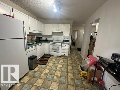 Kitchen featuring white cabinetry, light blue countertops, and checkered floor tiling - 18020 96 Avenue, Edmonton, AB 