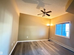 Room featuring wood-finish flooring, a ceiling fan, baseboard heating, and a window with blinds - 