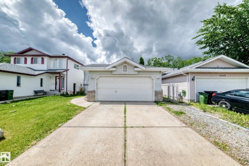 Single-story residence featuring light-colored siding, an attached two-car garage, and a concrete driveway - 13124 36 Street, Edmonton, AB 