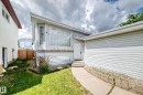 Light gray siding exterior with a large picture window, an integrated garage, and a concrete pathway - 13124 36 Street, Edmonton, AB 