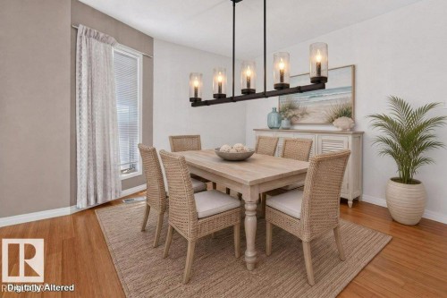 Dining area featuring a linear chandelier with five glass shades, wood-finish flooring, a window with blinds, and white baseboards - 16524 99 Street, Edmonton, AB 