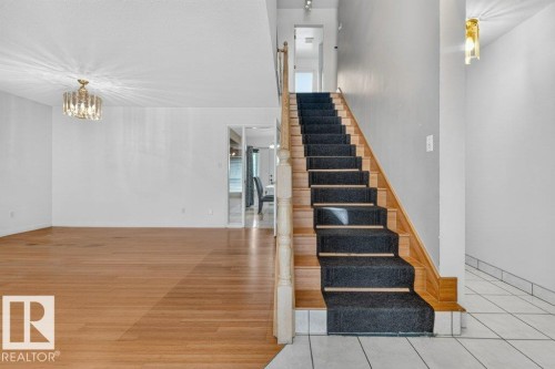 Wood-finish flooring and a crystal chandelier in the main living area - 16524 99 Street, Edmonton, AB 