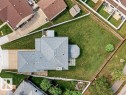 Expansive property featuring a gabled roofline, a large green lawn, a concrete driveway, a rear patio area, and a detached shed - 16524 99 Street, Edmonton, AB 