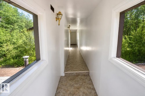 Hallway with light-colored flooring, white walls, and decorative wall sconces - 60528 Range Road 112, Rural St. Paul County, AB 