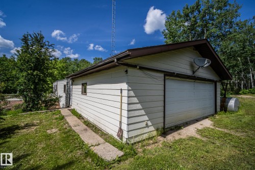 Detached garage with horizontal siding, a single overhead door, and a brown trim gable roof - 60528 Range Road 112, Rural St. Paul County, AB 