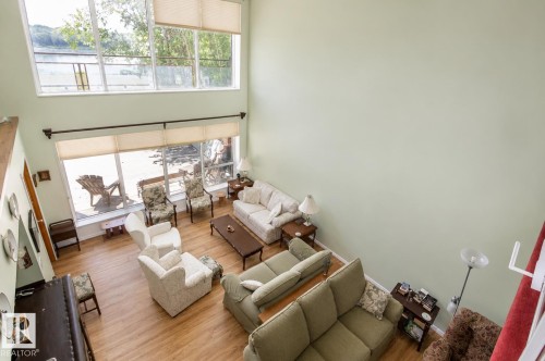 Open-concept living space featuring high ceilings, wood-finish flooring, and large windows - 60528 Range Road 112, Rural St. Paul County, AB 