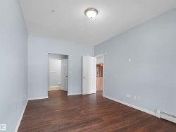 Spacious interior featuring wood-finish flooring, light blue wall paint, and white trim - 