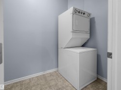 Dedicated laundry area featuring a stacked washer and dryer unit - 