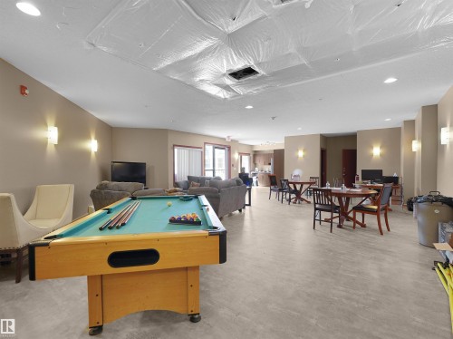 Spacious common area featuring light-toned flooring and recessed ceiling lights - 106 263 Macewan Road, Edmonton, AB 