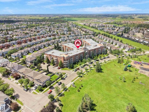 Multi-story residential building featuring extensive brickwork, multiple balconies, and a central courtyard - 106 263 Macewan Road, Edmonton, AB 