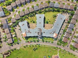 Aerial perspective showcasing a multi-unit residential building with a central courtyard - 
