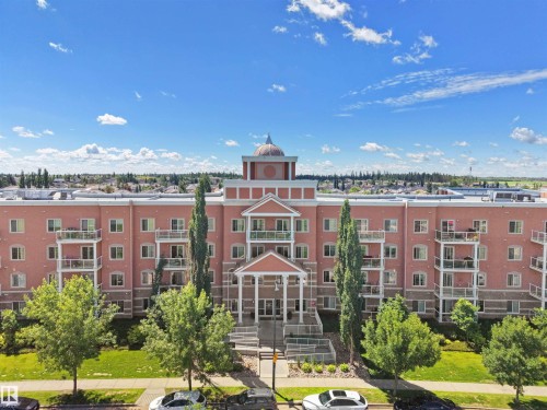 Multi-story residential building featuring a prominent front entrance with columns, a portico, and a central domed architectural element - 106 263 Macewan Road, Edmonton, AB 