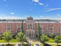 Multi-story residential building featuring a prominent front entrance with columns, a portico, and a central domed architectural element - 106 263 Macewan Road, Edmonton, AB 