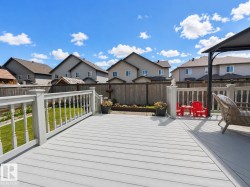 Spacious outdoor deck featuring gray composite decking and white baluster railing - 