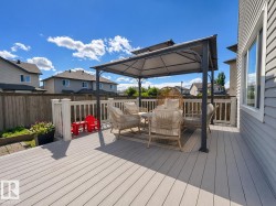 Expansive composite deck featuring a white railing system and a built-in gazebo - 
