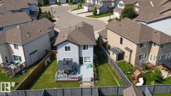 Light blue two-story residence featuring a brown shingle roof and white-framed windows - 