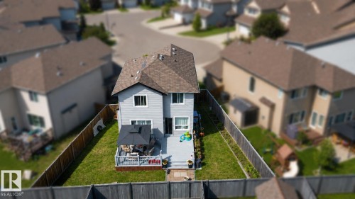 Rear exterior of a two-story residence featuring light gray siding, a brown shingle roof, and a fenced backyard - 526 173A Street, Edmonton, AB 