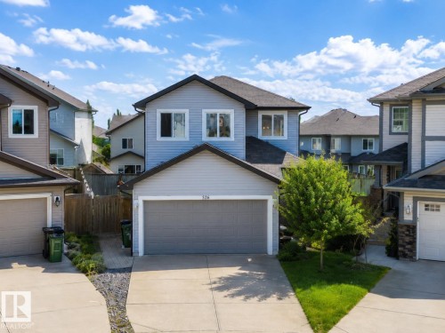 Two-story residence featuring light blue siding, a dark roof, and white window trim - 526 173A Street, Edmonton, AB 