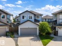 Two-story residence featuring light blue siding, a dark roof, and white window trim - 526 173A Street, Edmonton, AB 