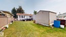 Expansive backyard featuring a manicured lawn, established trees, and a detached storage shed - 12812 45 Street, Edmonton, AB  - Outdoor With Exterior 