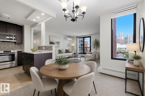 Open-concept living area featuring a kitchen with dark wood-finish cabinetry, stainless steel appliances, and a mosaic tile backsplash - 505 10145 109 Street, Edmonton, AB 