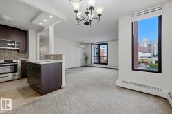Kitchen and living area featuring dark wood-finish cabinetry, stainless steel appliances, a tiled backsplash, and recessed lighting - 