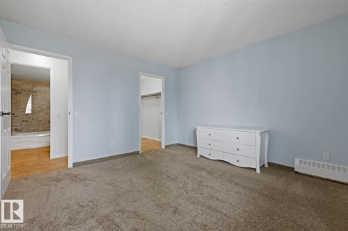 Spacious room featuring light blue walls and neutral-toned carpeting - 505 10145 109 Street, Edmonton, AB 
