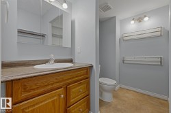 Bathroom featuring a light wood-finish vanity with a built-in sink, a neutral-toned countertop, and an overhead mirrored medicine cabinet - 
