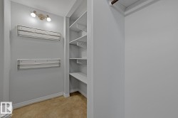 Built-in shelving unit providing extensive storage, complemented by wall-mounted towel bars and overhead track lighting - 