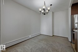 Dining area featuring carpet flooring, a multi-bulb chandelier, and a baseboard heating element - 