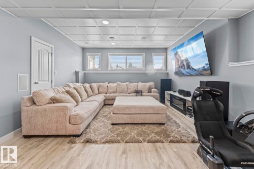 Spacious room featuring wood-finish flooring, a coffered ceiling with recessed lighting, and a built-in media console with an electric fireplace - 35 Falcon Road, Cold Lake, AB 