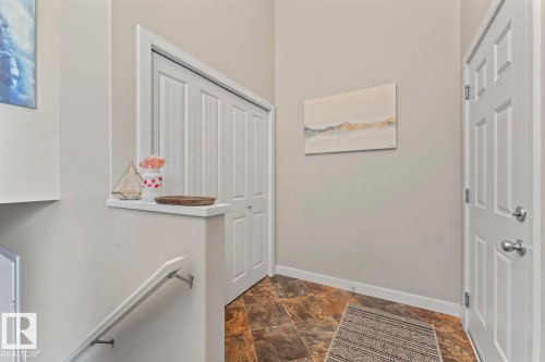 Entryway featuring durable slate-look tile flooring, a paneled entry door with brushed nickel hardware, and a bifold closet - 35 Falcon Road, Cold Lake, AB 