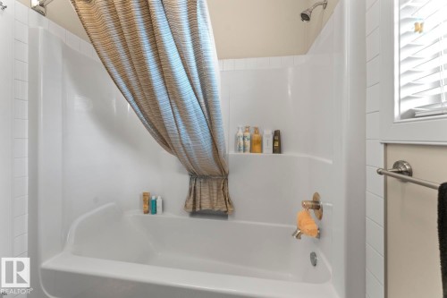 Bathroom featuring a white bathtub and shower combination with an integrated shelving unit - 35 Falcon Road, Cold Lake, AB 