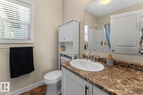 Bathroom featuring a vanity with a brown patterned countertop, a built-in sink, and a chrome faucet - 35 Falcon Road, Cold Lake, AB 