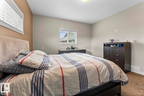 Bedroom featuring two windows with horizontal blinds, neutral wall paint, and brown carpet flooring - 35 Falcon Road, Cold Lake, AB 