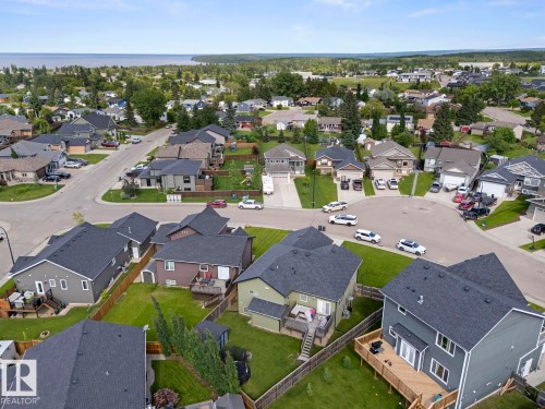 Aerial perspective of a residential neighborhood featuring detached homes with dark shingled roofs and private backyards - 35 Falcon Road, Cold Lake, AB 