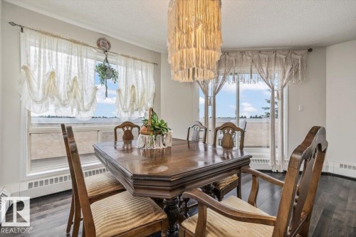 Dining area featuring wood-finish flooring, a large window, and a glass-paneled door - 427 15499 Castle Downs Road, Edmonton, AB 