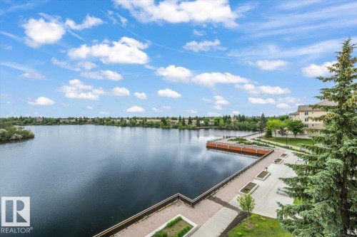 Expansive waterfront with a paved promenade featuring seating areas and integrated planters - 427 15499 Castle Downs Road, Edmonton, AB 