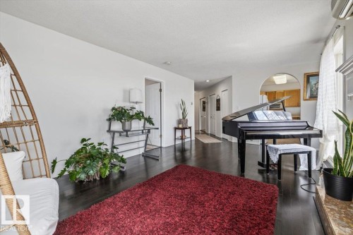 Spacious living area featuring dark wood-finish flooring and light-colored walls - 427 15499 Castle Downs Road, Edmonton, AB 