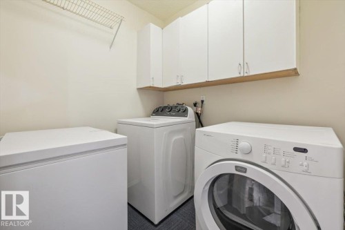 Utility space featuring built-in white cabinetry, a wire shelving unit, and neutral wall tones - 427 15499 Castle Downs Road, Edmonton, AB 