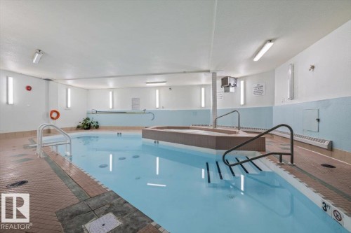 Indoor aquatic area featuring a swimming pool, integrated spa, and tiled surround - 427 15499 Castle Downs Road, Edmonton, AB 