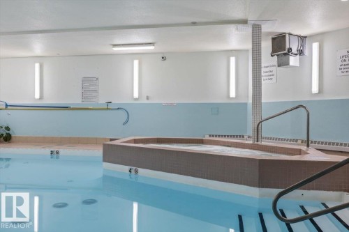 Indoor swimming pool featuring a tiled spa and stainless steel handrails - 427 15499 Castle Downs Road, Edmonton, AB 