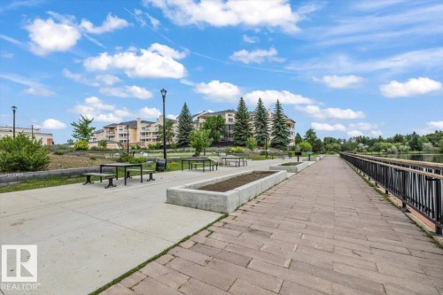 Paved promenade bordering a body of water with a sturdy black railing - 427 15499 Castle Downs Road, Edmonton, AB 