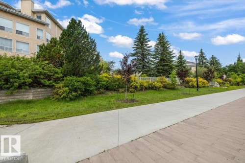 Concrete pathway alongside a planted green space - 427 15499 Castle Downs Road, Edmonton, AB 