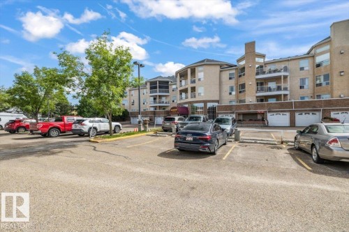 Multi-story residential building featuring balconies and ground-level garage access - 427 15499 Castle Downs Road, Edmonton, AB 