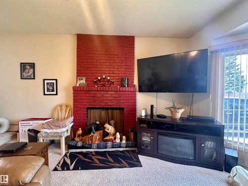 Red brick fireplace feature wall with a hearth - 10619 108 Avenue, Westlock, AB - Indoor With Fireplace