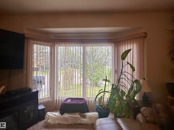 Bay window featuring vertical blinds and a neutral-toned valance - 