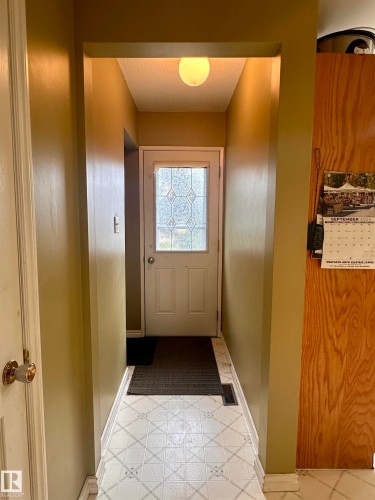 Entryway featuring patterned tile flooring, a white door with decorative glass inserts, and a flush-mount ceiling light fixture - 10619 108 Avenue, Westlock, AB - Indoor Photo Showing Other Room