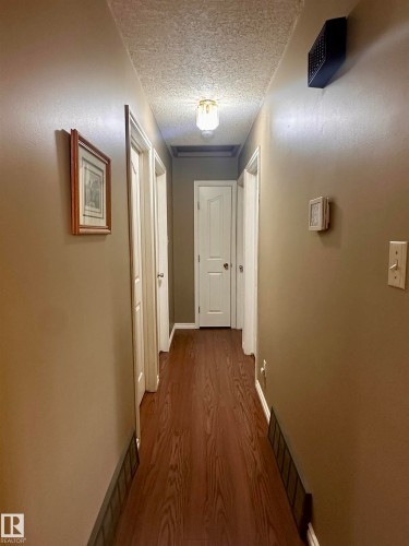 Hallway featuring wood-finish flooring and a textured ceiling - 10619 108 Avenue, Westlock, AB - Indoor Photo Showing Other Room